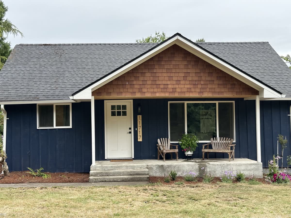 A finished whole home remodel, board and batten siding with a cedar shake gable and a covered porch